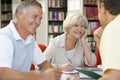 Adult students working together in a library