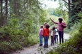 Adult Team Leaders With Group Of Children At Outdoor Activity Camp Walking Through Woodland