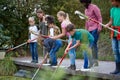 Adult Team Leaders Show Group Of Children On Outdoor Activity Camp How To Catch And Study Pond Life Royalty Free Stock Photo