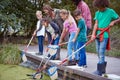 Adult Team Leaders Show Group Of Children On Outdoor Activity Camp How To Catch And Study Pond Life Royalty Free Stock Photo