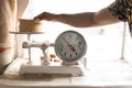 An adult tortilla maker is weighing a kilo of tortillas using an analog scale Royalty Free Stock Photo