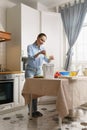 Adult white woman composting food leftovers in a bokashi bin. Housewife recycling organic waste in a compost container in a