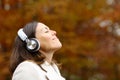 Adult woman breathing fresh air with headphones in autumn Royalty Free Stock Photo