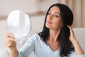 Adult woman checking her face in mirror Royalty Free Stock Photo