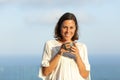 Adult woman with coffee cup looking at you in a balcony Royalty Free Stock Photo