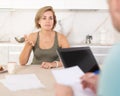 Adult woman discussing deal with salesman in kitchen