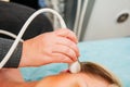Adult woman doctor scanning head vessels on the head with ultrasound device scan. Selective focus