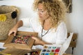 Adult woman doing hand made creations jewelry at home with colorful beads and cords - female people working at home for online Royalty Free Stock Photo