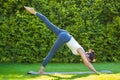 Adult woman doing yoga in sunny morning park