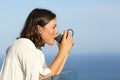 Adult woman drinking coffee cup in a balcony Royalty Free Stock Photo