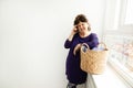 Adult woman emotionally, gesturing, talking on phone . dirty laundry basket with clothes. homework concept Royalty Free Stock Photo