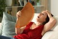 Adult woman fanning suffering heat stroke at home