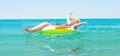 Adult woman floating in a rubber ring in the sea. Royalty Free Stock Photo