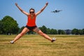 Adult woman at Gravelly Point Park in Washington DC jumps as an airplane flies in for a landing at the DCA Reagan International Royalty Free Stock Photo