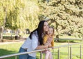 adult woman having fun with her child daughter in green park