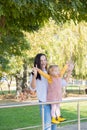 adult woman having fun with her child daughter in green park