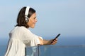 Adult woman with headphones listens music on a balcony Royalty Free Stock Photo