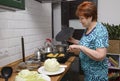 Adult woman in the kitchen preparing stuffed peppers and cabbage