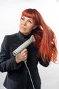 An adult woman, lady, with long red hair, dries her hair with a hairdryer. on white background. Hair care Royalty Free Stock Photo