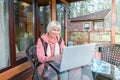 Adult woman with laptop on scenic terrace. Work from home. Remote job