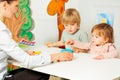 Adult woman with little kids play educative games