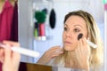 Woman applying highlight makeup on face