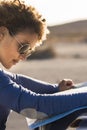 Adult woman looking paper travel road trip map on the car outside with landscape in background - concept of female people Royalty Free Stock Photo