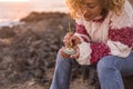 Adult woman painting a stone with mandala design outdoor in leisure artistic activity Royalty Free Stock Photo