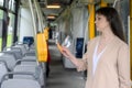 An adult woman pays with a plastic card for public transport in a bus, tram or subway