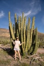 Adult woman poses with a large Organ Pipe Cactus in Arizona at the National Monument