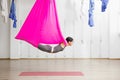 Adult woman practices anti-gravity yoga position in gym. Royalty Free Stock Photo