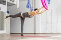 Adult woman practices balancing stick anti-gravity yoga position in studio