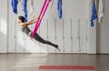 Adult woman practices inversion anti-gravity yoga position in gym. Royalty Free Stock Photo