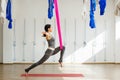 Adult woman practices inversion anti-gravity yoga position Royalty Free Stock Photo