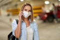 Adult woman in protection mask using cellphone in underground parking lot Royalty Free Stock Photo