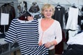 Adult woman purchaser choosing striped dress