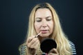 Adult woman putting some lipstick on her lips. Make up indoors Royalty Free Stock Photo