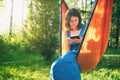Adult woman reading e-book or using tablet while sitting in hammock chair on nature. Cottagecore, slow life in countryside, relax Royalty Free Stock Photo