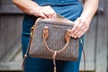 Adult woman searching in her purse. Michael Kors handbag close-up