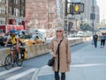 Adult woman seen waiting to cross a busy New York road. Royalty Free Stock Photo