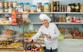 Adult woman seller offering sweets Royalty Free Stock Photo