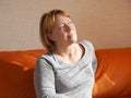 An adult woman sits lost in thought on the couch Royalty Free Stock Photo