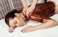 Adult woman in spa salon having body relaxing massage, lying on Royalty Free Stock Photo