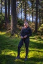 Woman standing in the forest, hiking in Glendalough, Wicklow Mountains, Ireland