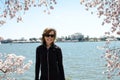 Adult woman stands and poses by Cherry Blossom trees and the Thomas Jefferson Memorial in Washington DC Royalty Free Stock Photo