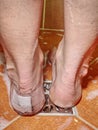 Woman take shower with paster on heel blister