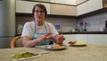 Adult woman tells recipe for blog, in kitchen interior.