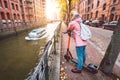 Adult woman tourist with backpack on e-scooter enjoying most famous historic Speicherstadt warehouse district of Hamburg