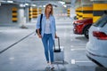 Adult woman tourist in underground airport parking lot