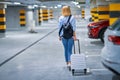 Adult woman tourist in underground airport parking lot